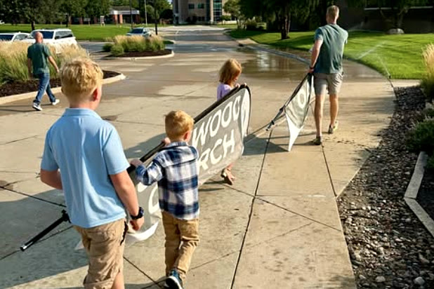 Kids carrying the Oakwood Church banner out to the sidewalk